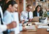 Peltola Turmoil: Ugly Slur Claims Explode Two colleagues reviewing a laptop in a modern office