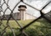Prison watchtower behind chain-link fence