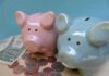 Deficit Doomsday: Taxpayers Gutted Pink and blue piggy banks with coins and dollar bills