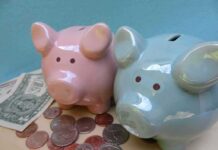 Deficit Doomsday: Taxpayers Gutted Pink and blue piggy banks with coins and dollar bills