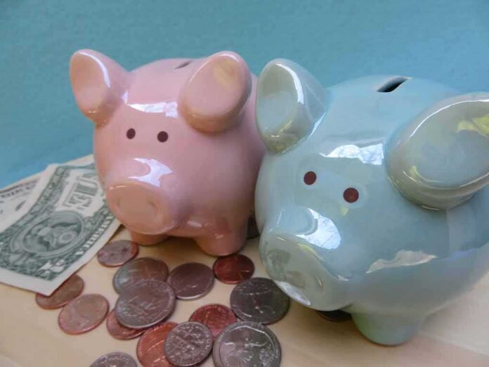 Pink and blue piggy banks with coins and dollar bills