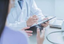 Doctors Busted? Detroit Pill Pipeline Exposed Doctor writing on clipboard during patient consultation