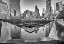 A memorial water feature surrounded by tall buildings in a city
