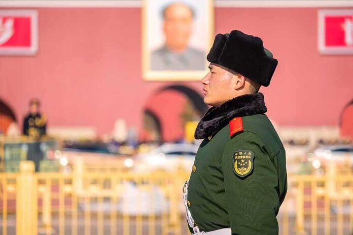 uniformed guard in green coat and fur hat standing in profile outdoors
