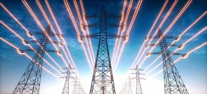 shutterstock_1975010111 High-voltage transmission towers with glowing power lines