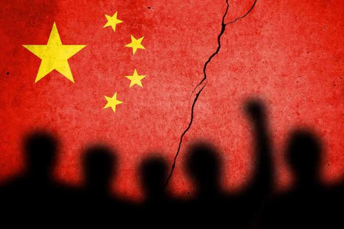 Chinese flag with crack and crowd silhouettes