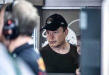 Elon Musk Turbocharges Red Ground Game Elon Musk wearing a black cap in a crowded indoor setting