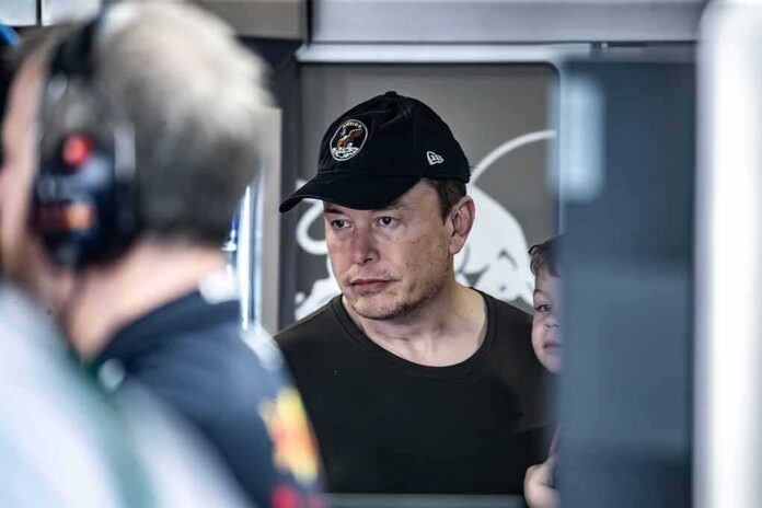 shutterstock_2303710497 Elon Musk wearing a black cap in a crowded indoor setting