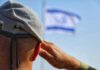 Soldier saluting with a blurred flag in the background