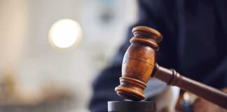 Judge's gavel striking a sound block on a wooden desk
