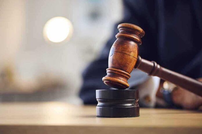 shutterstock_2346359661 Judge's gavel striking a sound block on a wooden desk