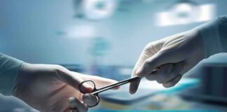 Gloved hands passing surgical scissors in an operating room