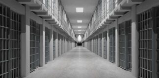 Prison corridor lined with barred cells on both sides