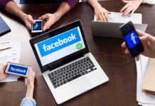 Laptop with Facebook on screen surrounded by smartphones
