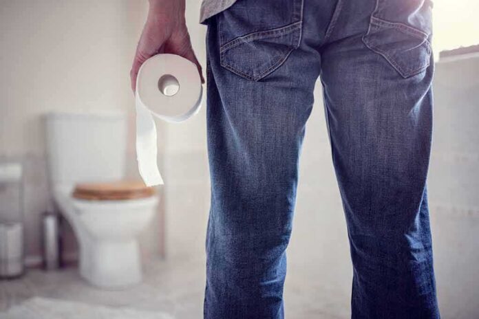 shutterstock_644195584 Person holding a toilet paper roll in a bathroom